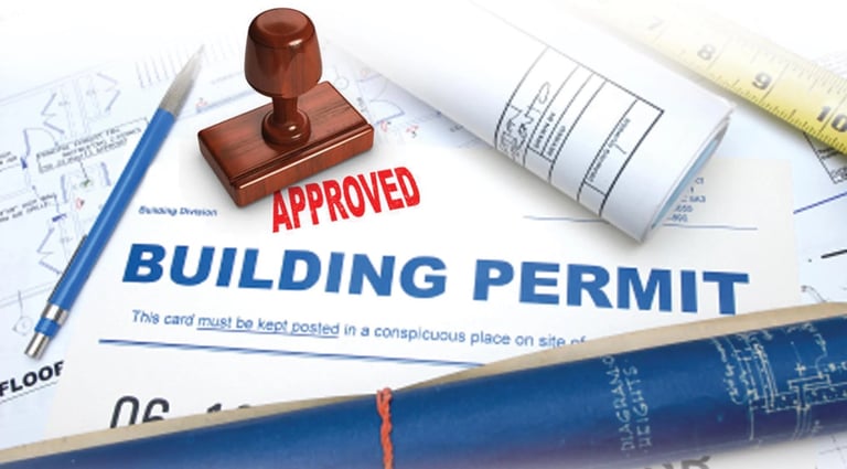 Approved building permit with red stamp on architectural blueprints and construction plans